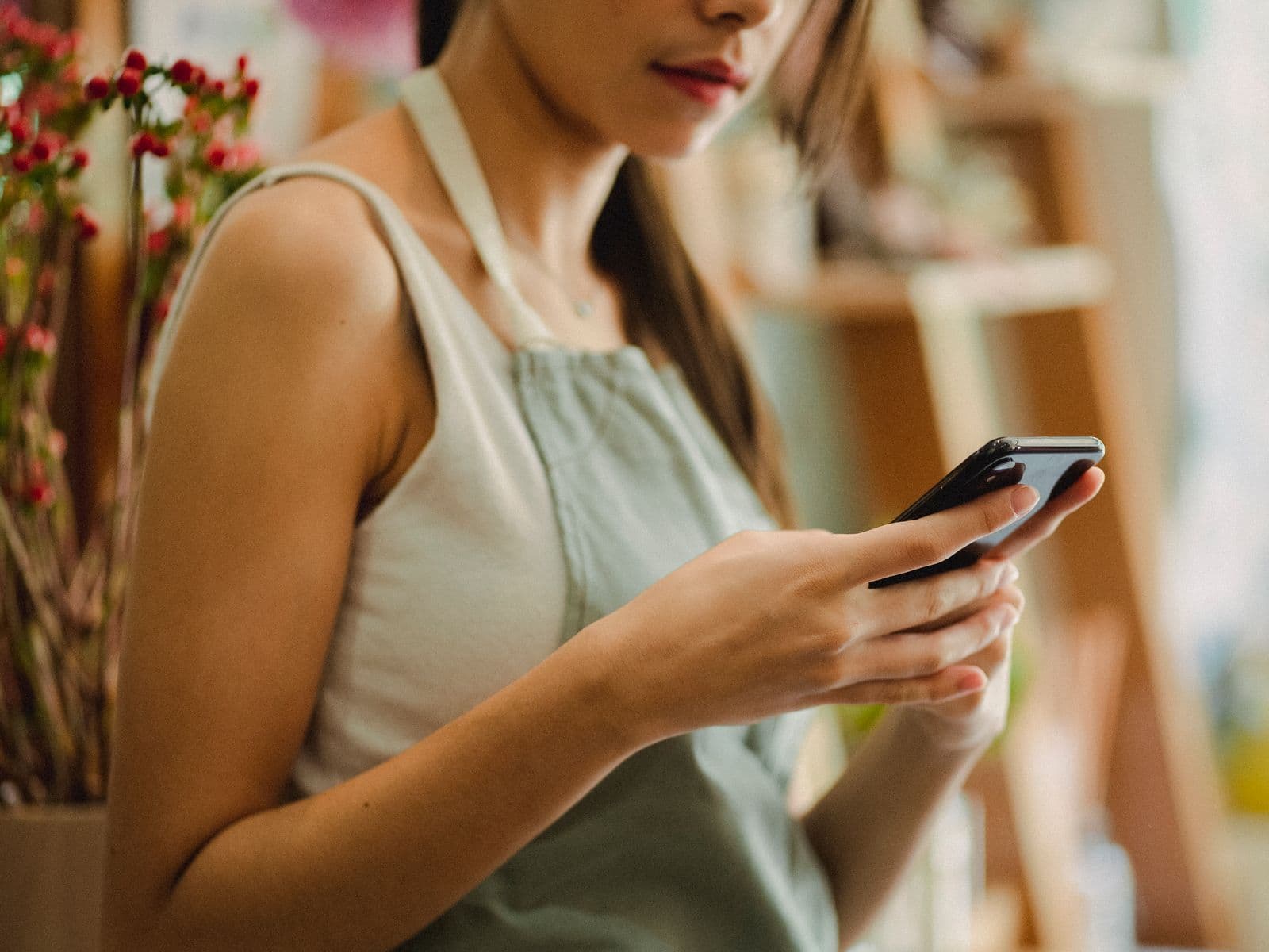 Fleuriste consultant son smartphone dans sa boutique de quartier